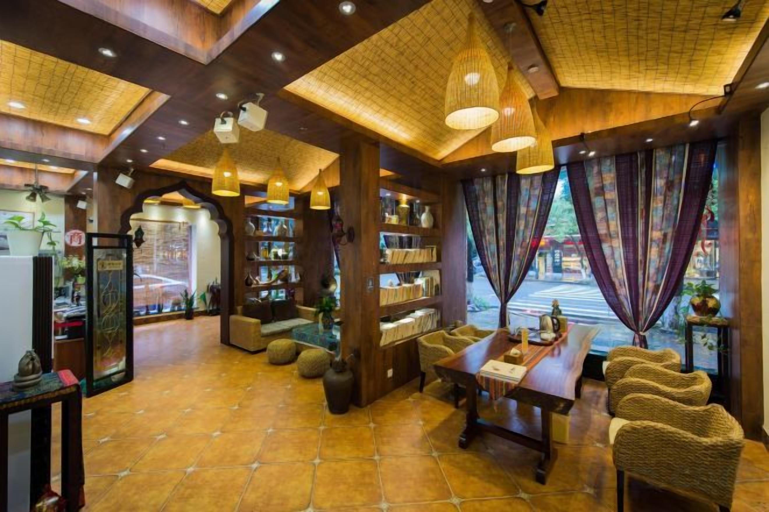 A cozy interior with a wooden ceiling, a dining area, and a view through large windows.