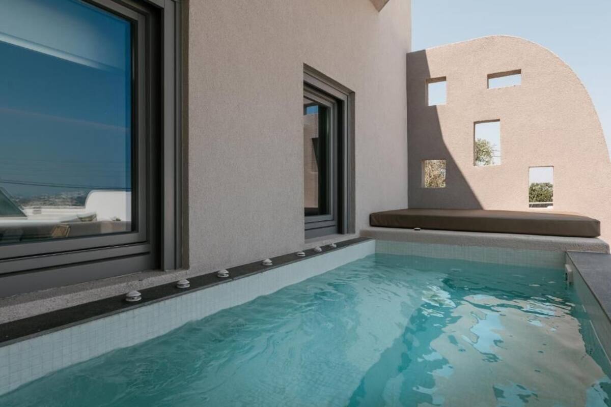 A modern pool area with a clear view of the pool, a window, and a unique architectural design with cut-out windows.