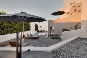 A rooftop pool area with lounge chairs, umbrellas, and a hot tub. - Elements Cozy Suites (Santorini)