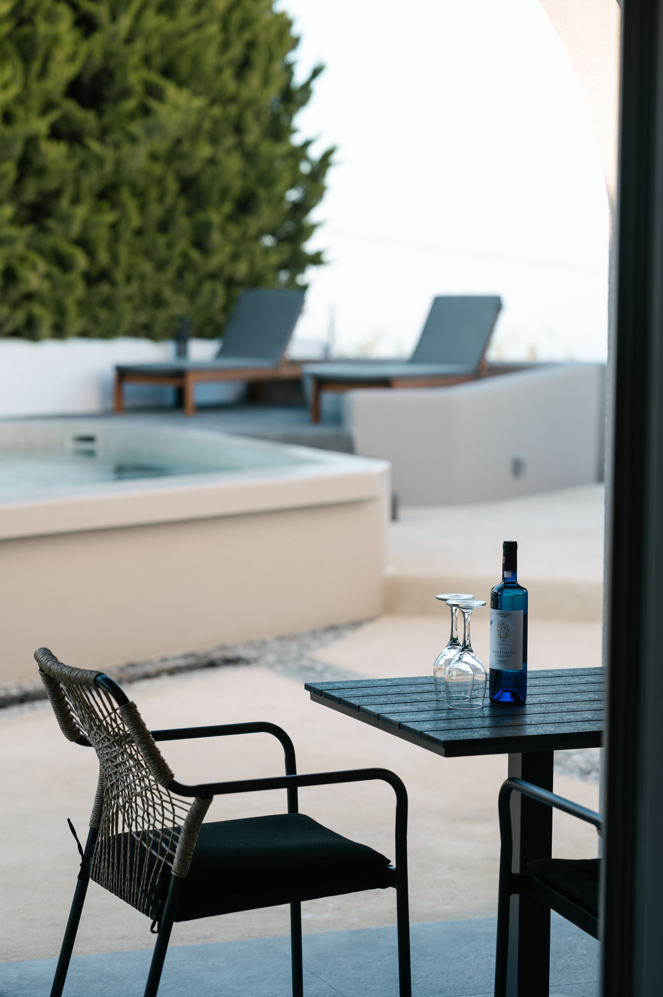 A patio area with a table, chairs, and a hot tub.