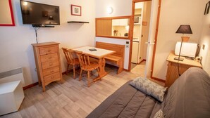 A compact living space with a kitchenette, a dining area, and a sofa. - 70m from ski slopes, 4th floor, view mountain, balcony, parking, tv, ski locker, 20m², Valfréjus (Valfréjus)