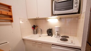 A compact kitchenette with a microwave, coffee maker, and toaster on the countertop. - 70m from ski slopes, 4th floor, view mountain, balcony, parking, tv, ski locker, 20m², Valfréjus (Valfréjus)