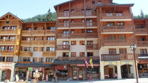 Ein mehrstöckiges Holzgebäude mit Balkonen, einem Restaurant und Geschäften im Erdgeschoss.