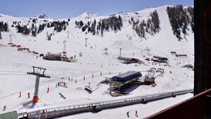A ski resort with ski lifts, a chairlift, and a snow-covered mountain backdrop. - 100m from ski slopes, 8th floor, view ski slopes, balcony, tv, ski locker, 28m², La Plagne (La Plagne)
