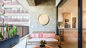 A modern interior with a wicker sofa, a round woven wall hanging, and a potted plant on a wooden table. - ✶ Maras Residence ✶ LUXURY Rooftop Pool & Grill (Miraflores)