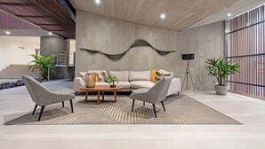 A modern living area with a sofa, two armchairs, a coffee table, and a decorative wall piece. - ✶ Maras Residence ✶ LUXURY Rooftop Pool & Grill (Miraflores)