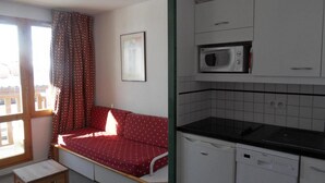 Una habitación compacta con sofá, una mesita, microondas y lavavajillas.