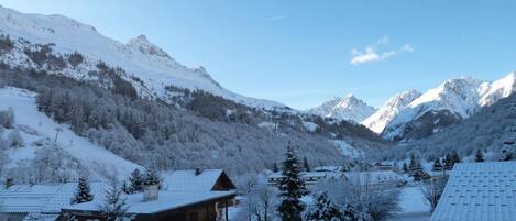 A snow-covered mountain village with wooden buildings and a clear sky.