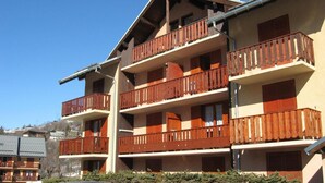 A multi-story building with wooden balconies and a sloped roof. - 350m from ski slopes, balcony, parking, tv, ski locker, 24m², Valloire (Valloire)