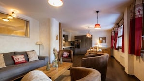 A modern living room with a sofa, armchairs, a coffee table, and pendant lighting. - 220m from ski slopes, floor -1, ski locker, 85m², Valloire (Valloire)