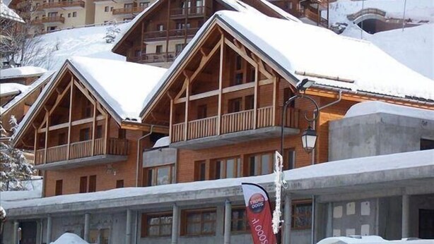 A row of wooden chalet-style buildings with balconies, covered in snow, indicating a winter setting. - 220m from ski slopes, floor -1, ski locker, 85m², Valloire (Valloire)
