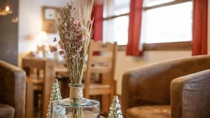 A wooden table with a glass vase containing dried flowers and a small Christmas tree ornament. - 220m from ski slopes, floor -1, ski locker, 85m², Valloire (Valloire)