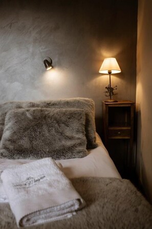 Una camera da letto con un letto, una lampada e un comodino.