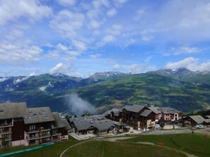 A mountain resort with chalet-style buildings, a ski lift, and a view of snow-capped mountains. - 10m from ski slopes, 1st floor, view valley, balcony, tv, ski locker, 24m², Peisey-Vallandry (Landry)