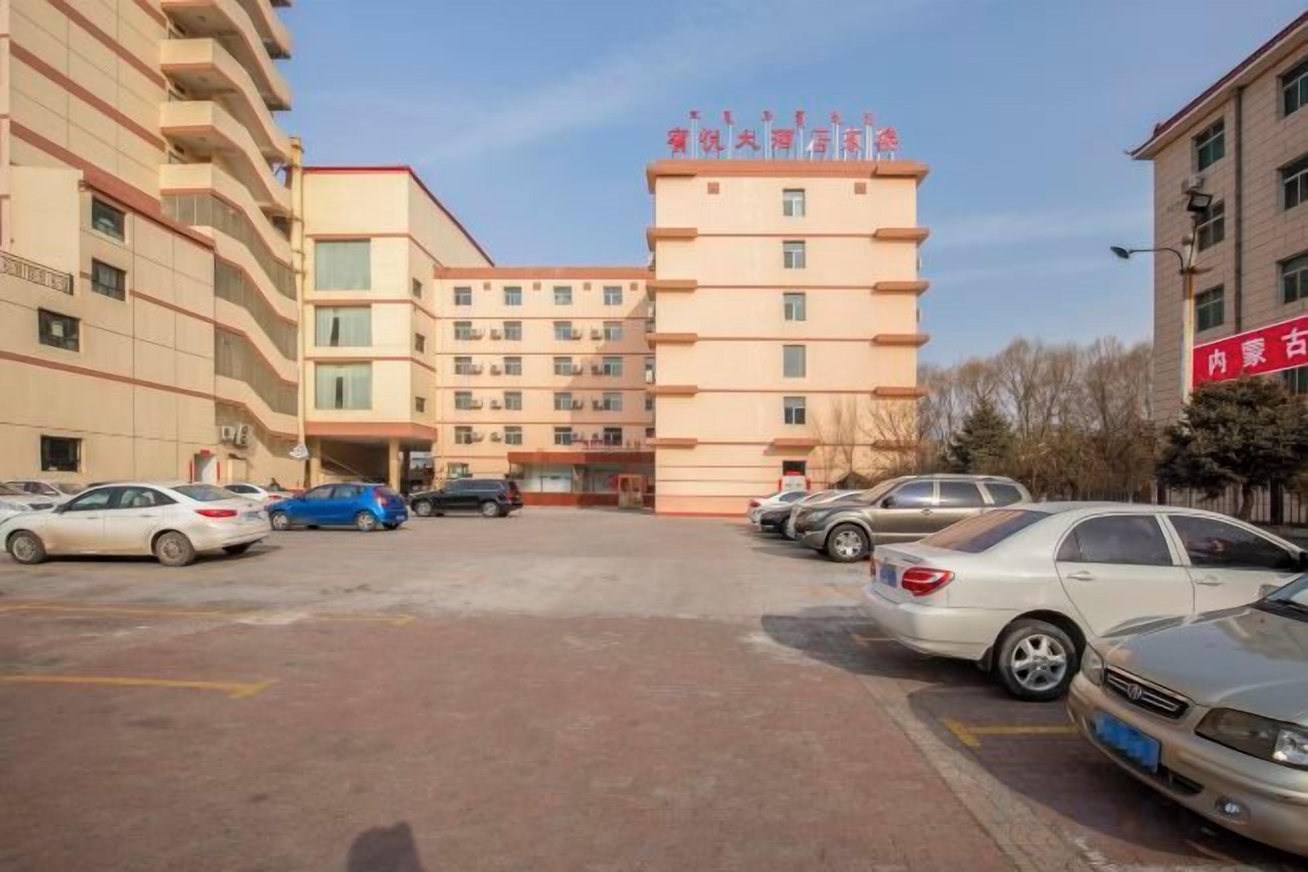 Un edificio de varios pisos con estacionamiento al frente.