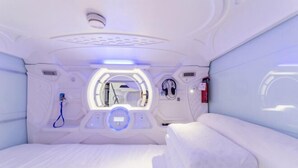A room with a bed, a control panel, and a circular window. - Binyue Hotel (East Building) (Hohhot)