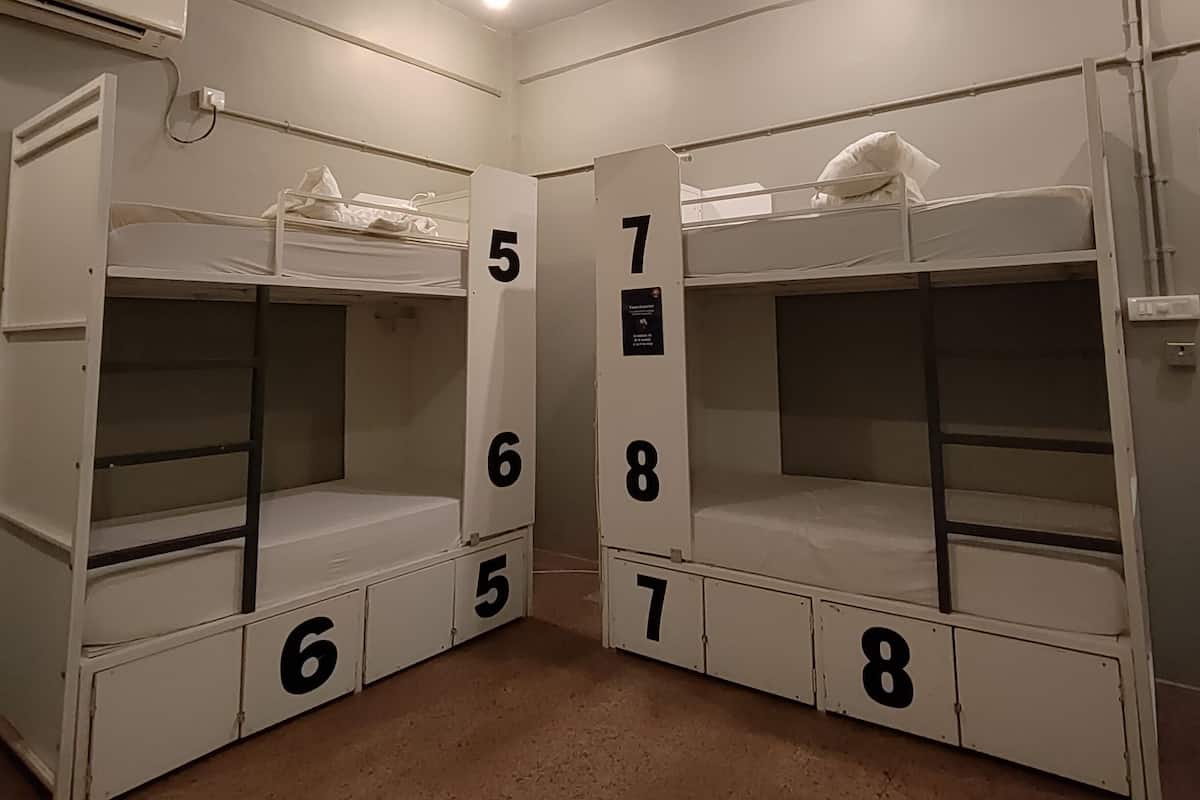 A bunk room with numbered bunk beds and a ceiling fan.