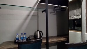 Une chambre compacte comprenant un lit superposé, un petit bureau avec deux chaises et un distributeur d’eau.