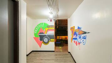 A hallway with a mural of a car and the words "TAXI" and "KITCHEN" on the walls.