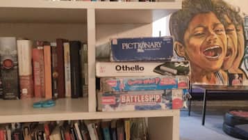 A bookshelf with various books and board games.