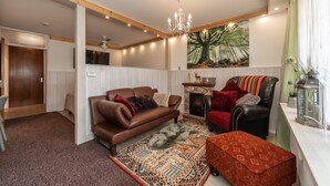 Un salon chaleureux avec un canapé en cuir marron, un tapis à motifs et une cheminée.