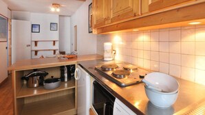 Een keuken met houten kastjes, een rvs aanrecht, een koffiezetapparaat en een vaatwasser.