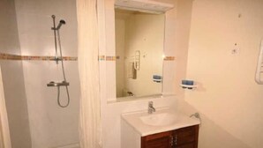 A bathroom with a shower, a sink, and a mirror. - 150m from ski slopes, 2nd floor, view resort, fitness, swimming pool, sauna, tv, ski locker, 29m² (Eaux-Bonnes)
