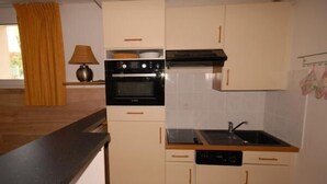 A compact kitchen with a stove, oven, sink, and dishwasher. - 150m from ski slopes, 3rd floor, view resort, fitness, swimming pool, sauna, tv, ski locker, 35m² (Eaux-Bonnes)
