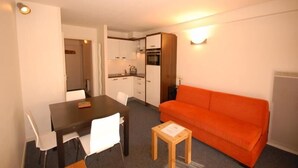 A compact living space with a dining table, chairs, a sofa, and a kitchenette. - 30m from ski slopes, 1st floor, view ski slopes, tv, 24m², Gourette (Eaux-Bonnes)