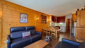 A wooden interior with a sofa, dining table, and kitchen area. - 1st floor, balcony, tv, ski locker, 75m², Flaine (Flaine)