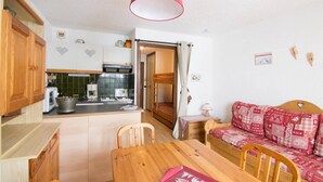 A compact kitchen with a dining area and a sofa.