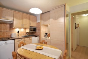 A compact kitchen with wooden cabinets, a microwave, a toaster, and a coffee maker. - Ski-in/ski-out & foot of the slopes, 4th floor, view ski slopes, balcony, tv, 28m², La Plagne (La Plagne)