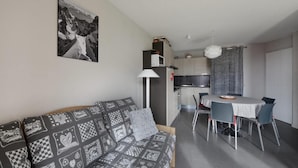 A compact living space with a sofa, a dining table, and a kitchenette. - 20m from ski slopes, Ground floor, view ski slopes, tv, 40m², La Plagne (La Plagne)