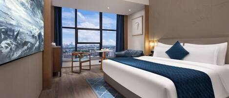 A modern hotel room with a large bed, a desk, and a view of the city.