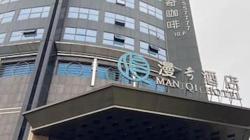 Ein Hotel im modernen Design, mit einem gut sichtbaren Logo und Hinweisschildern, die es als Manqi Hotel kennzeichnen.