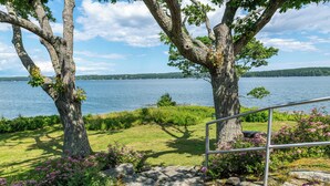 Une vue sur le lac, avec un escalier en pierre menant à une rambarde métallique surplombant l’eau.