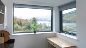 A room with a large window overlooking a scenic landscape, a wooden bench, and a knife set on the left. - 14 Loch View in Kenmore (Aberfeldy)