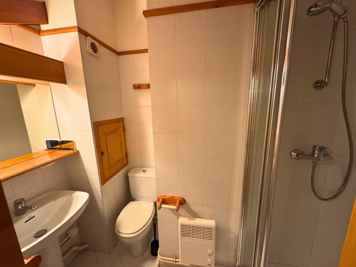 Un baño pequeño con lavamanos, inodoro y ducha.