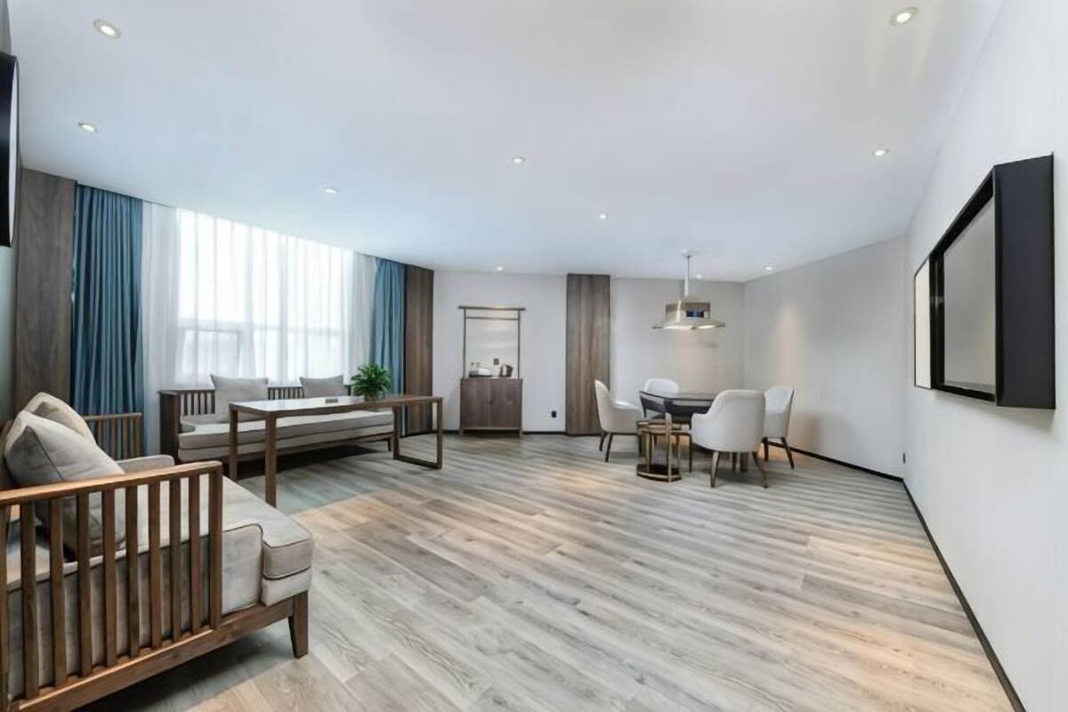 A modern living room with a sofa, a dining table, and chairs.
