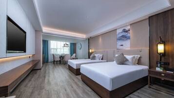 Habitación de hotel con dos camas, un televisor, un escritorio y una silla.