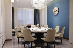A conference room with a round table, chairs, and a chandelier. - Linwu International Hotel (Linwu)