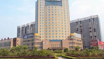 A multi-story hotel building with a prominent entrance and a landscaped area in front.