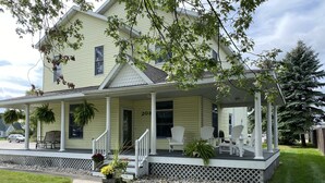 A two-story house with a covered porch, numbered 208, featuring white columns and a bench. - Betsy Ross,, Great Downtown,, Residence (Gaylord)
