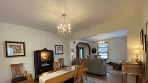A dining area with a wooden table and chairs, a chandelier, and a patterned rug. - Betsy Ross,, Great Downtown,, Residence (Gaylord)