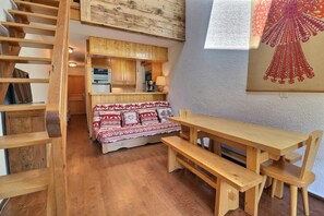 Un interior de madera con un sofá, una mesa de madera y bancos.