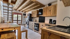 A kitchen with wooden cabinets, a stove, a microwave, and a sink.