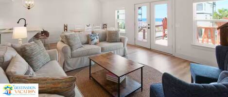 A spacious living room with a sofa set, a coffee table, and a ceiling fan.
