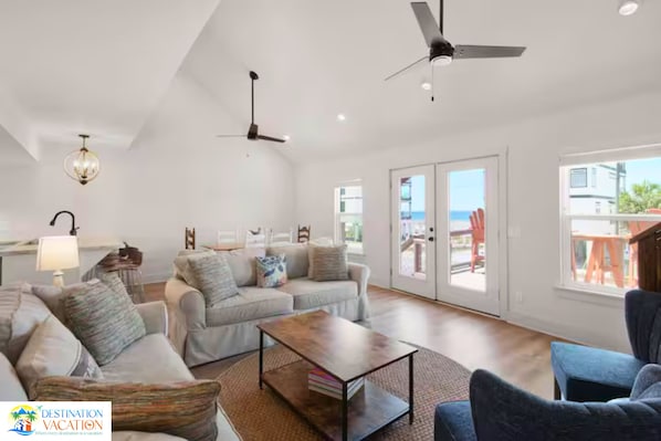 A spacious living room with a sofa set, a coffee table, and a ceiling fan.