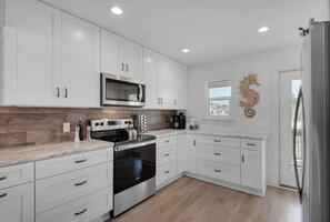 Enjoy cooking in this well-lit kitchen with an oven, microwave, and sleek cabinetry.