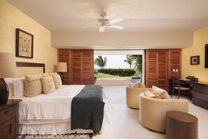 Quarto com cama, mesas de cabeceira, escrivaninha e vista para o exterior.